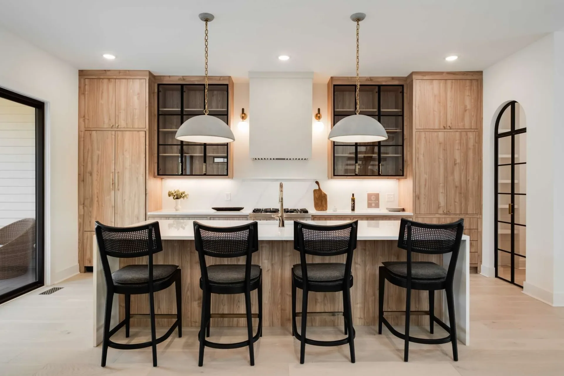 Light wood kitchen cabinetry with dark glazed upper cabinets