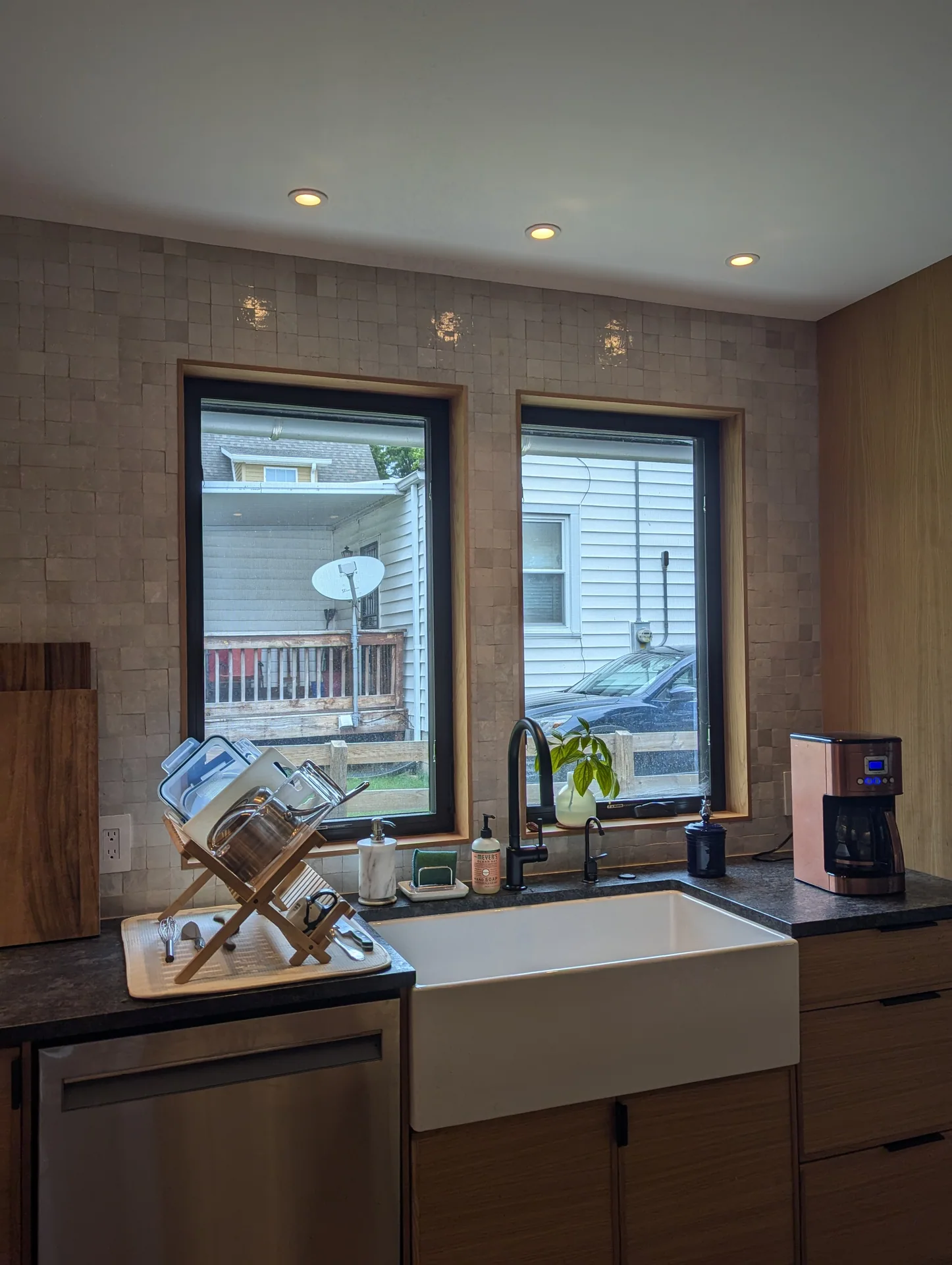 White apron-front sink beneath two dark-framed windows in the Mayfield Kitchen
