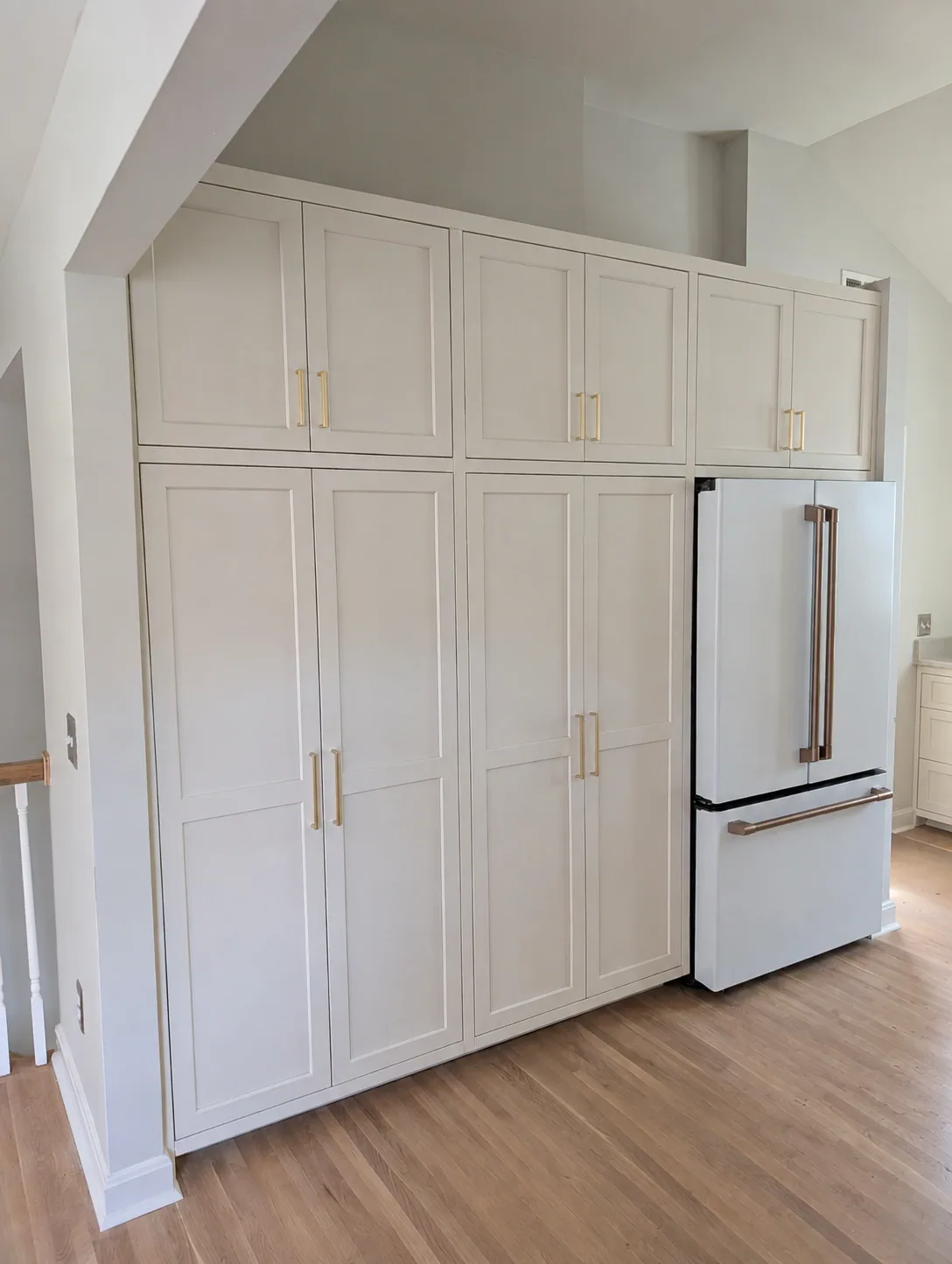 Full-height white pantry cabinetry and a paneled refrigerator surround in the Miller Kitchen